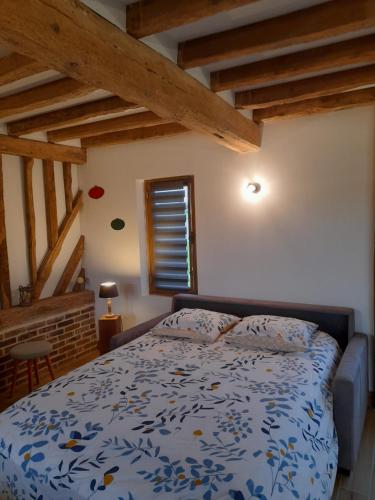 - une chambre avec un lit dans une pièce dotée de plafonds en bois dans l'établissement Gîte de la giroterie, maison à la campagne au calme, vue sur la vallée, 