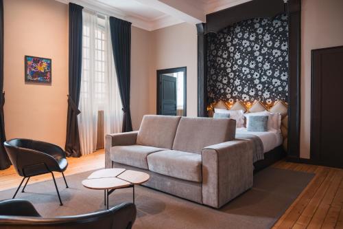 ein Wohnzimmer mit einem Sofa und einem Bett in der Unterkunft Le Monastère de Saint Mont Hôtel & Spa in Saint-Mont