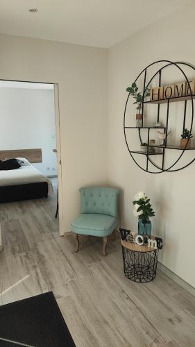 une chambre avec une chaise bleue et un lit dans l'établissement Studio mer, à La Plaine-sur-Mer