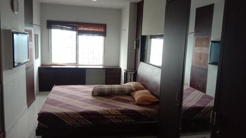 a bedroom with a bed and two windows at Apartemen Thamrin City 2 BIG BR,85sqm,City View in Jakarta