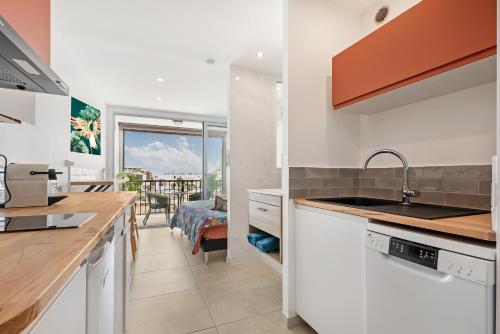 une cuisine avec un évier et un plan de travail dans l'établissement Pitaya Heliopolis, au Cap d'Agde