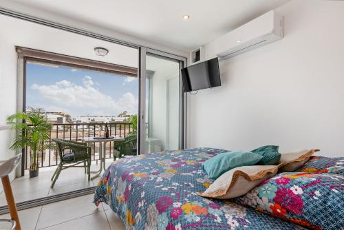 une chambre avec un lit et un balcon avec vue dans l'établissement Pitaya Heliopolis, au Cap d'Agde