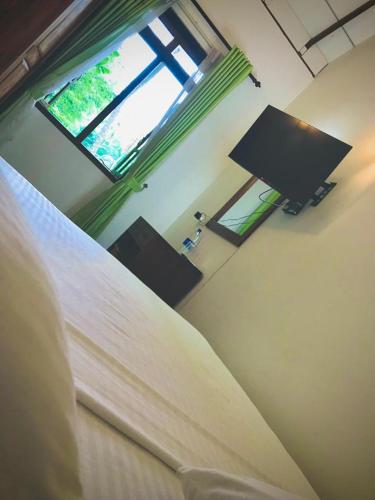 um quarto com uma cama e uma janela em Raddagoda walawwa Hottel em Kurunegala