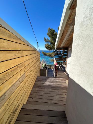 a wooden staircase leading to a house with a wooden fence at Cabanon moderne, les pieds dans l'eau, 2 chambres in Le Pradet