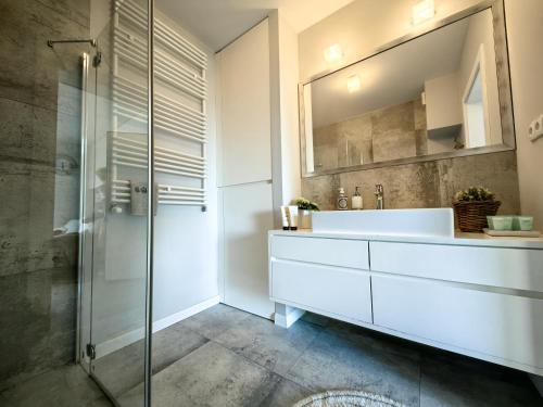 a bathroom with a white sink and a mirror at Edel Exclusive Apartments Horyzont 414 Especially for You in Międzyzdroje