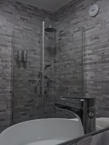 een badkamer met een bad en een douche bij Logis La P'tite Futée in Meymac