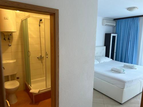 ein Bad mit einem Bett, einer Dusche und einem WC in der Unterkunft Apartmani Jukanovic in Baška Voda