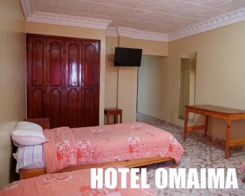 una camera d'albergo con due letti e un tavolo di Hotel OMAIMA a Laayoune