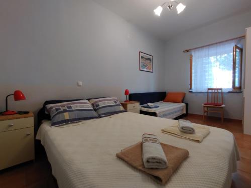 a bedroom with a large bed with towels on it at Guest House Dobriša in Vinišće