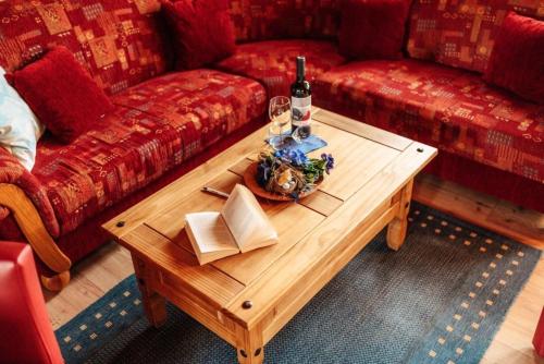 uma sala de estar com sofás vermelhos e uma mesa de madeira em Blockhaus 2 em Steina