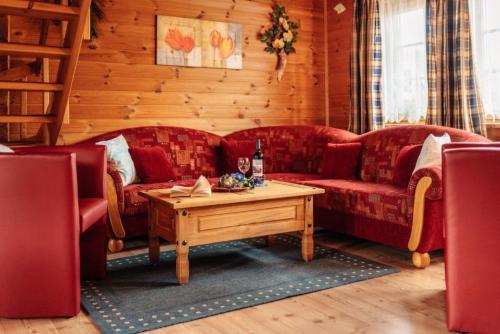 a living room with two red couches and a table at Blockhaus 2 in Steina