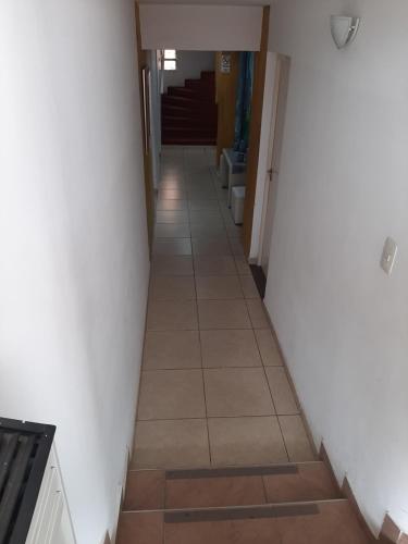 a hallway with a tile floor and white walls at Hotel Gran Córdoba in La Falda