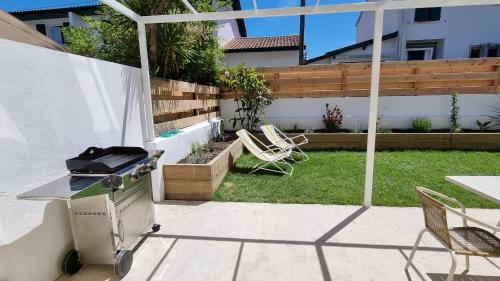 une arrière-cour avec un grill, une table et des chaises dans l'établissement Maison de pêcheur à 10 minutes à pied de Saint Jean de Luz, à Ciboure