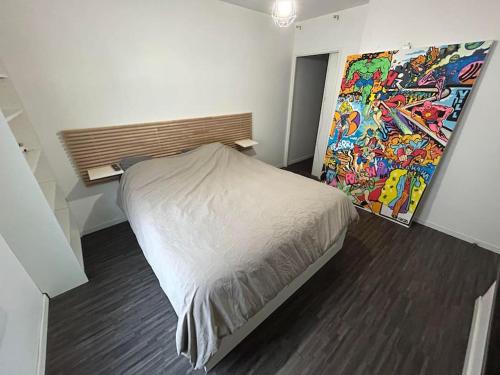 une chambre avec un lit et un tableau au mur dans l'établissement Marvel & DC modern appartment, à Saint-Ouen