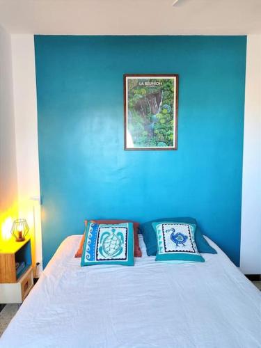 une chambre bleue avec un lit avec deux oreillers dans l'établissement CAP D AGDE, T2 loggia, 4 pers, plage MOLE 300m, au Cap d'Agde