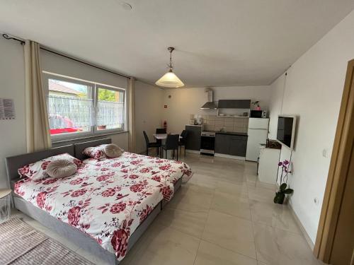 a bedroom with a large bed and a kitchen at Apartma Azurre in Postojna