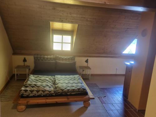 uma cama grande num quarto com tecto em madeira em Ferienwohnung Kefeder em Lochenhaus