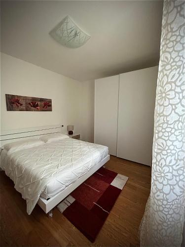 a bedroom with a white bed in a room at Il Piccolo Borgo in Valdobbiadene