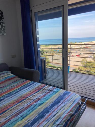 a bedroom with a bed and a view of the ocean at Beach Apartment in Vilanova i la Geltrú