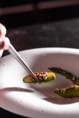 a person holding a utensil in a bowl of food at Le Monastère de Saint Mont Hôtel & Spa in Saint-Mont