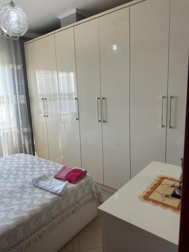 a bedroom with white cabinets and a bed at Roy Apartments in Durrës