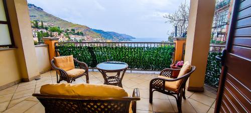 einen Balkon mit Stühlen, einem Tisch und Aussicht in der Unterkunft Casa Flavia in Taormina