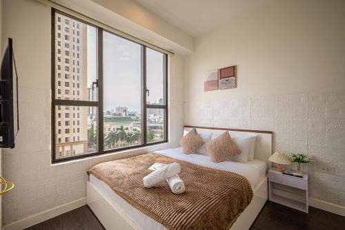 ホーチミン・シティにあるDOUBLE N Apartment - 3 Bedrooms in Central of Saigon - Free Pool, Gym - Riverside Viewのベッドルーム1室(タオル付きのベッド1台付)