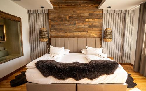 a bedroom with a large white bed with a black blanket at HANUL BUCOVINEI in Câmpulung Moldovenesc