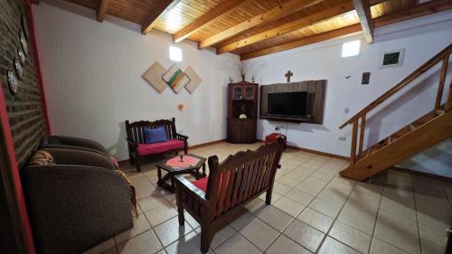 un soggiorno con un divano e una TV di La Casona de Mabel a Puerto Iguazú