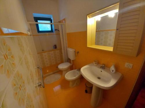 a bathroom with a sink and a toilet and a mirror at Breezes B&B in Conca Specchiulla