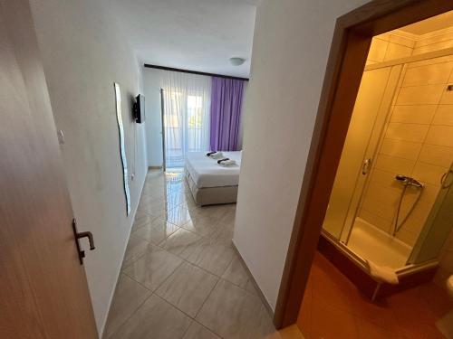 Zimmer mit einem Bett und einer Tür zu einem Schlafzimmer in der Unterkunft Apartmani Jukanovic in Baška Voda