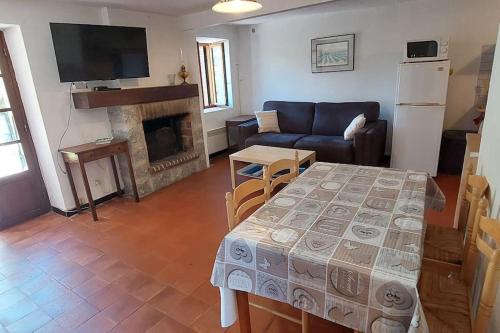 un salon avec une table et un canapé dans l'établissement Usupranu Maison de village à 15 mn de la mer, à Sari-dʼOrcino