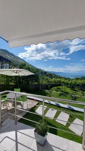 eine Terrasse mit Tisch und Sonnenschirm in der Unterkunft R&R GESTHOUSE in Shirokë