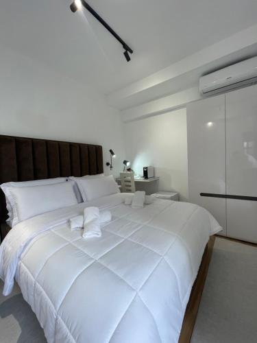 a large white bed with two white towels on it at Vila Nela in Shkodër