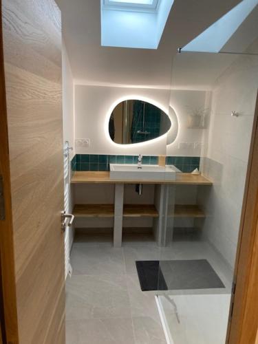 une salle de bain avec un lavabo et un miroir dans l'établissement Deux charmantes maisons proche de l'océan., à LʼAiguillon-sur-Vie