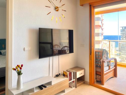 un salon avec une télévision à écran plat sur un mur dans l'établissement Refugio De Hedonista, alojamiento con encanto, à Calp