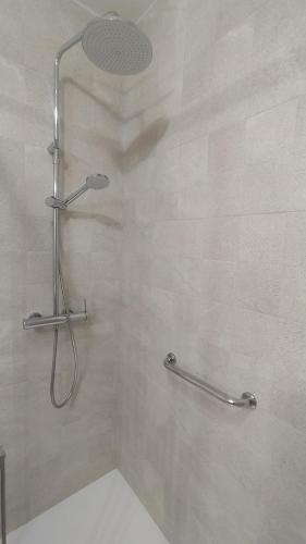 un bagno con doccia e porta in vetro di Son Bou Bonito y renovado Apartamento ad Alaior