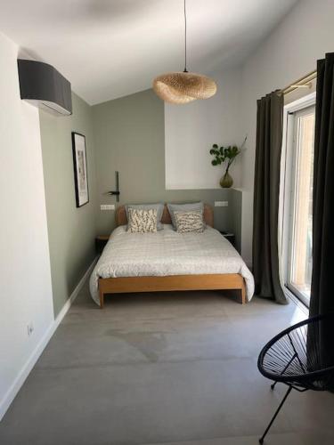 une chambre avec un lit et une grande fenêtre dans l'établissement Magnifique Mas avec Piscine Luberon (Gordes), à Murs