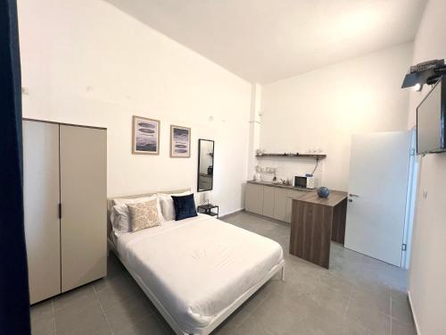 a bedroom with a white bed and a kitchen at Carmel Market center apartments TLV in Tel Aviv
