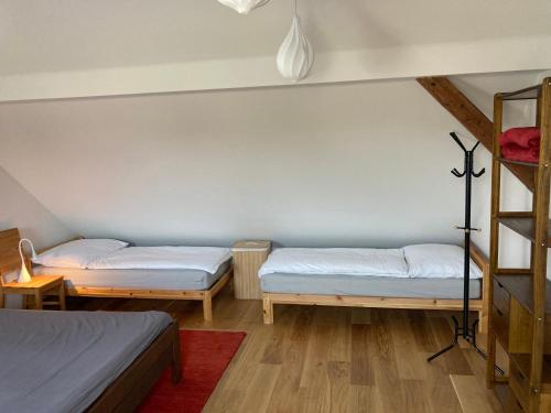 a room with two beds and a ladder at Stodola 63 in Pacov
