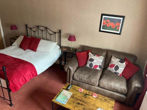 a bedroom with a bed and a couch and a table at Birchwood House in Church Stretton