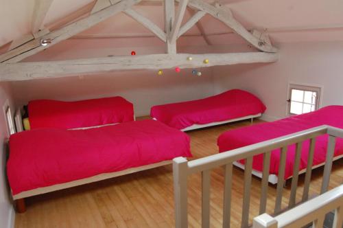 Cette chambre comprend 2 lits superposés dotés de draps rouges. dans l'établissement Retour aux sources, à Blanquefort-sur-Briolance