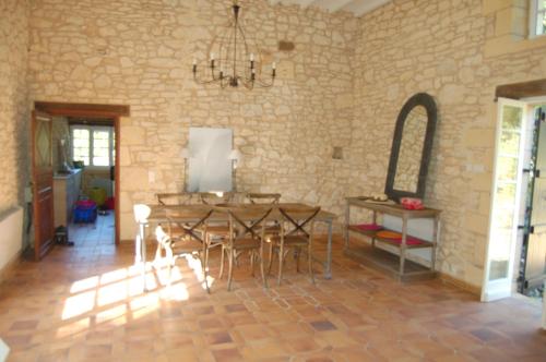 une salle à manger avec une table, des chaises et un miroir dans l'établissement Retour aux sources, à Blanquefort-sur-Briolance