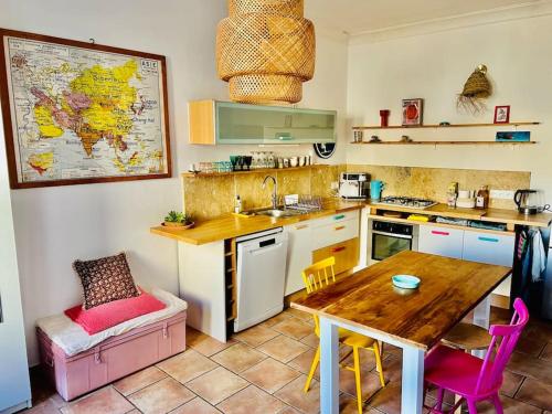 - une cuisine avec une table, une table et des chaises dans l'établissement Maisonnette au cœur du village, à Châteauvieux