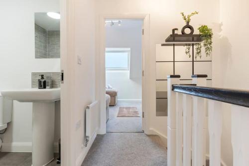 a white bathroom with a sink and a mirror at Luxury City Centre 5 Bed House with FREE parking in Birmingham
