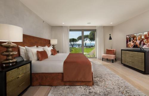 a bedroom with a large bed and a tv at Steiner in Saint-Tropez