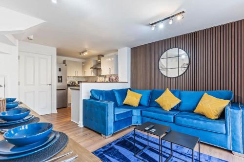 a living room with a blue couch and a kitchen at Luxury City Centre 5 Bed House with FREE parking in Birmingham