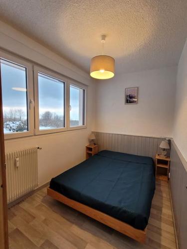 - une chambre avec un grand lit dans une pièce dotée de fenêtres dans l'établissement Très bel appartement avec vue, à Thollon-les-Mémises