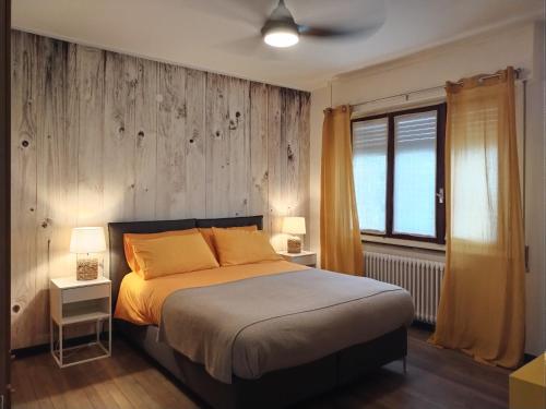 a bedroom with a bed and two lamps and a window at La Casina Sondrio Valtellina in Sondrio