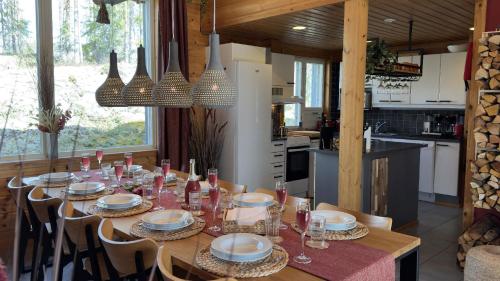 a dining room with a table with plates and glasses at Villa Kolovesi - Saimaa Retreat in Savonlinna